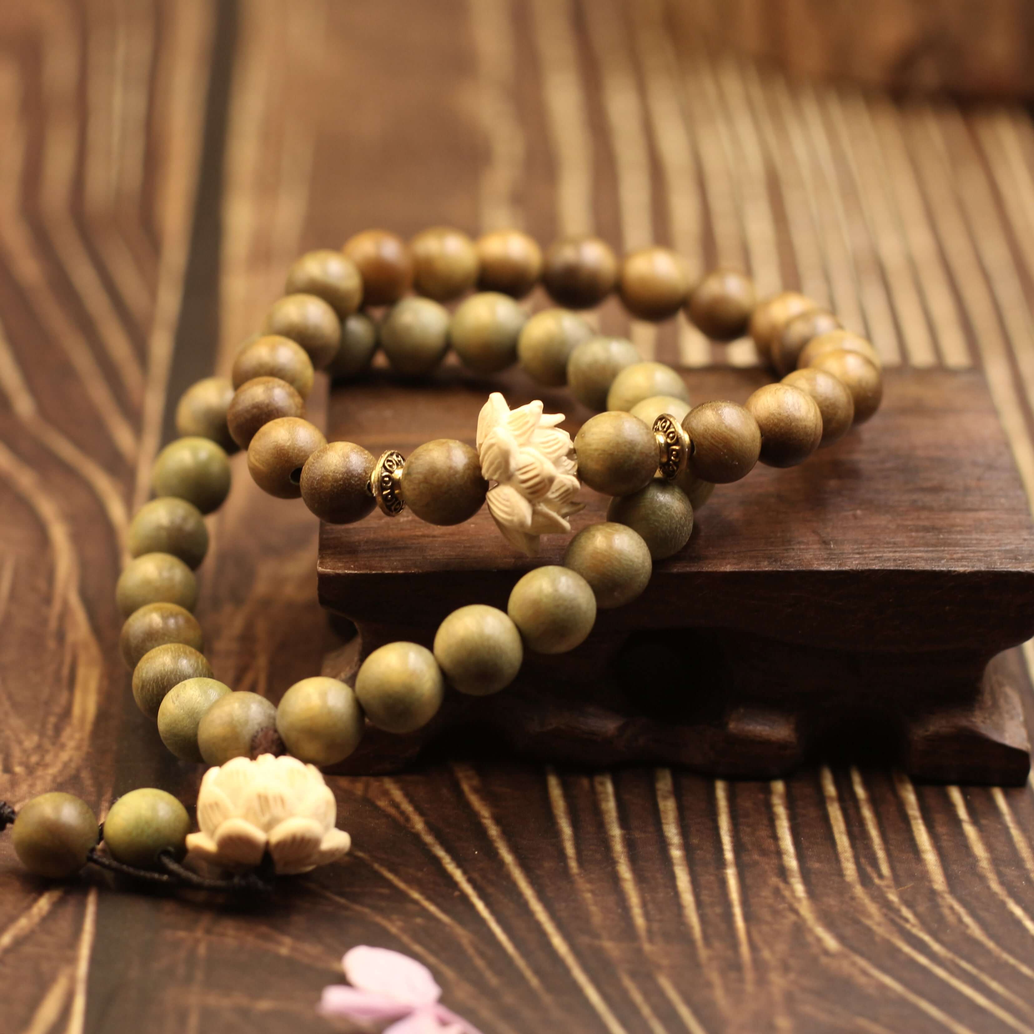 Peaceful Lotus Bracelet in light green beads symbolizing purity and wisdom, placed on a wooden stand, promoting inner peace and serenity