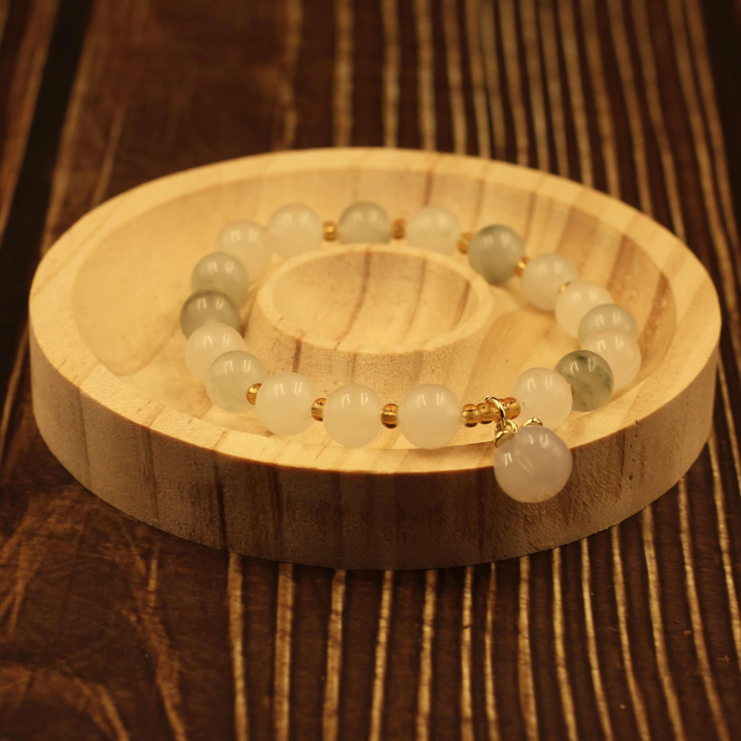 Yanyuan Agate Peach Bracelet on wooden display, showcasing its unique colors and textures for health and peace benefits.
