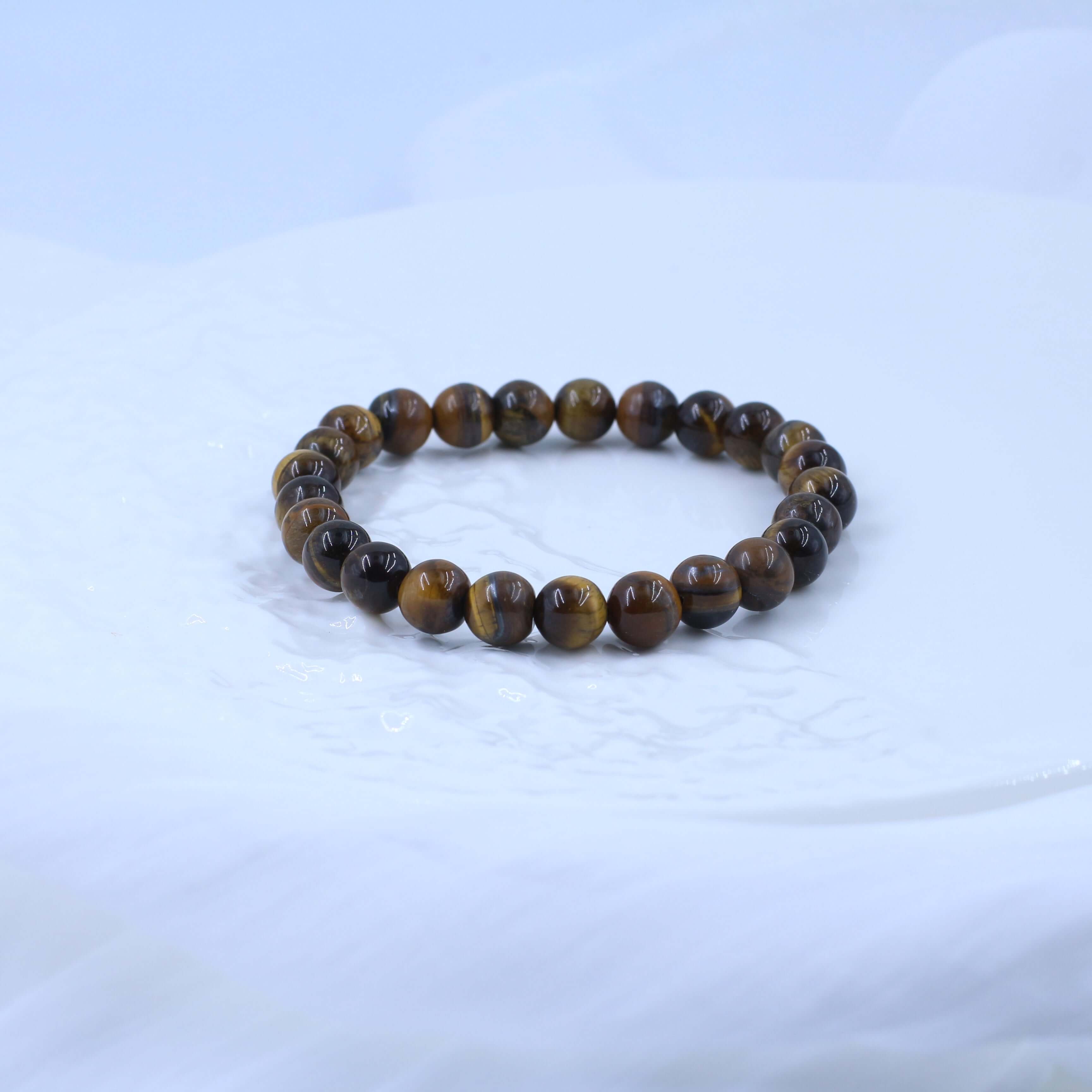 Classic Yellow Tiger's Eye Bracelet with warm hues for strength and spiritual growth, resting on a smooth surface.