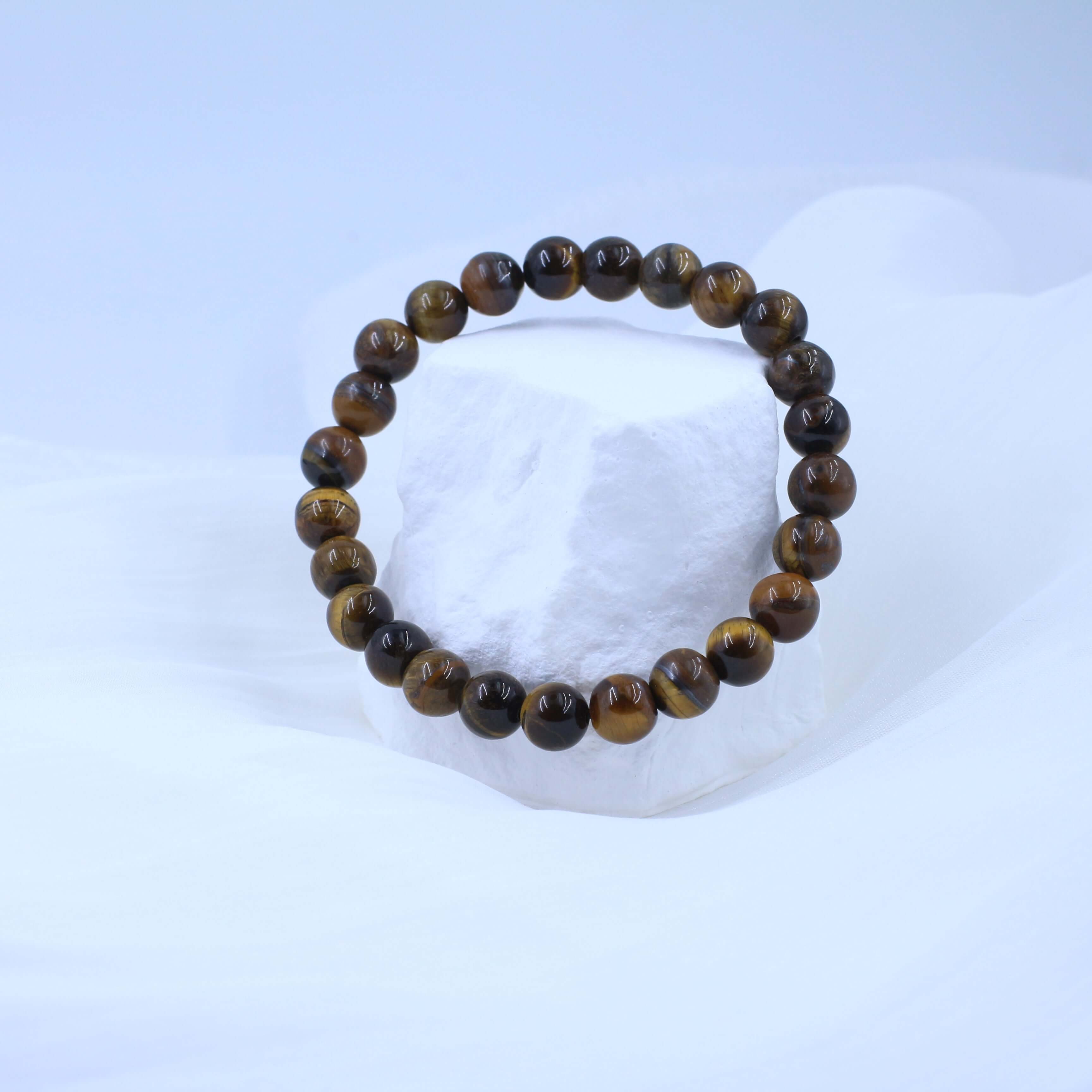 Classic Yellow Tiger's Eye Bracelet on White Stone Display, Spiritual Strength Jewelry